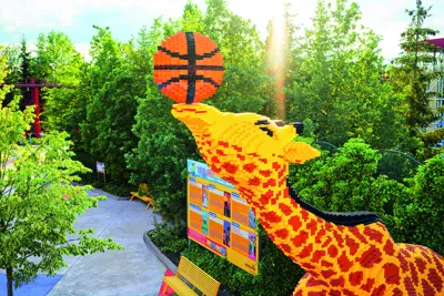 Large giraffe made of LEGO bricks with a basketball on its nose at LEGOLAND Deutschland