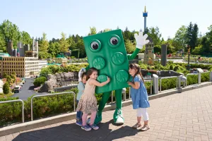 Kinder im LEGOLAND mit großer LEGO Stein Figur in Farbe grün