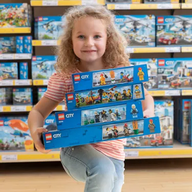 ein Mädchen mit LEGO Bausets im LEGOLAND City Shop