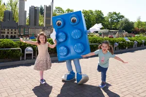 zwei Kinder im LEGOLAND mit großer LEGO Stein Figur in Farbe blau